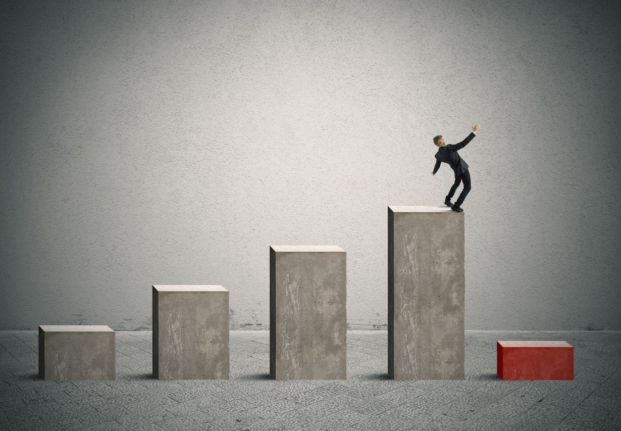 A man standing on top of a bar while balancing himself.